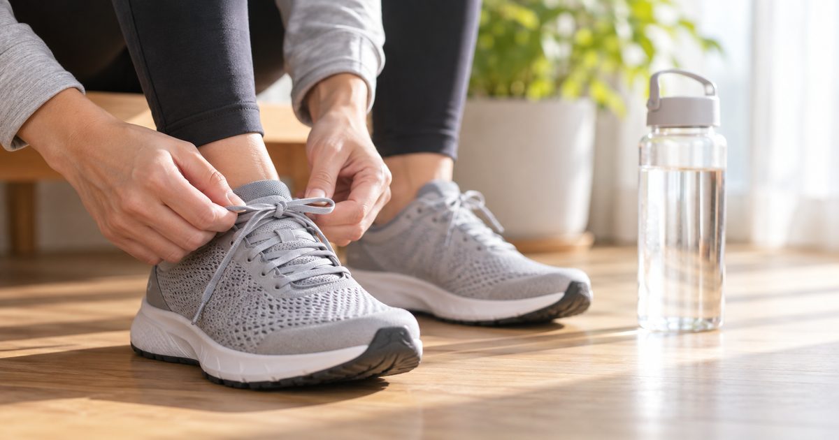 運動靴のひもを結んで外出を準備する手元
